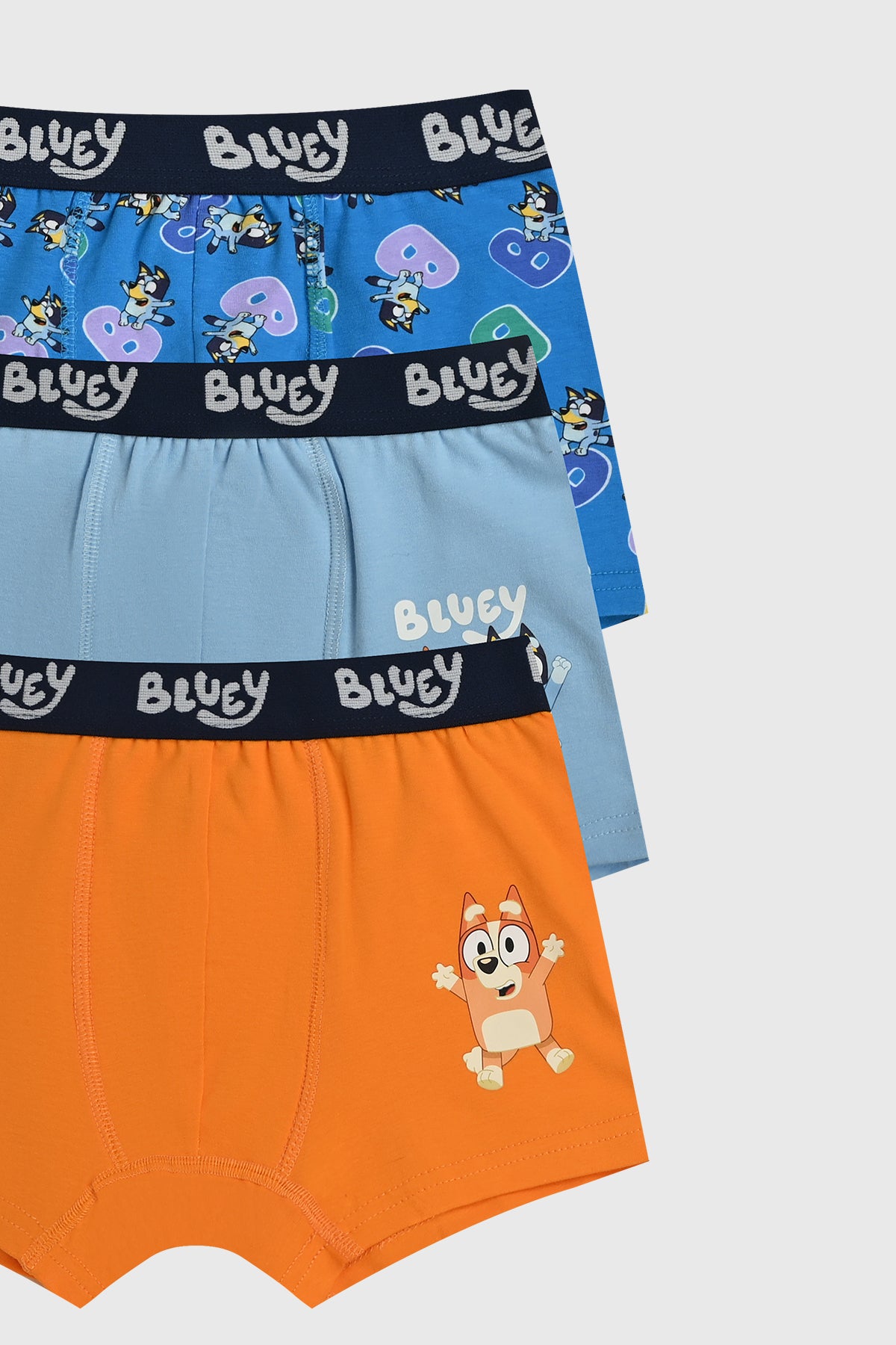 Boxer niño tripack celeste con estampado Bluey en la cintura uno azul con personajes y otro naranja con personaje pequeño