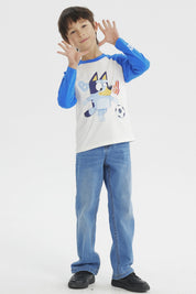 Polera crudo de niño con mangas azules y estampa de Bluey jugando fútbol al frente en estilo animado