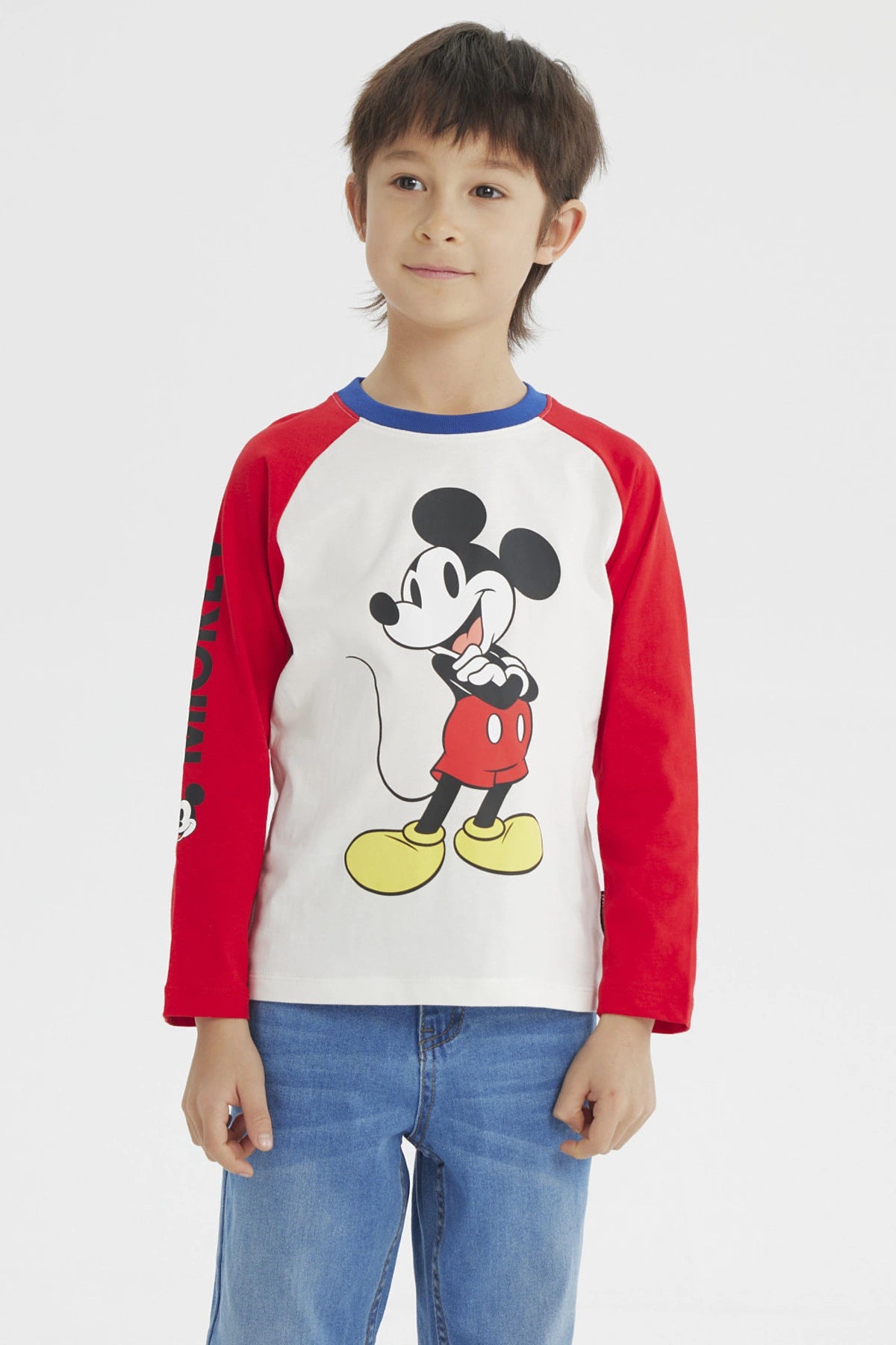 Polera beige de niño con estampado grande de Mickey Mouse en el frente estilo clásico con mangas largas rojas