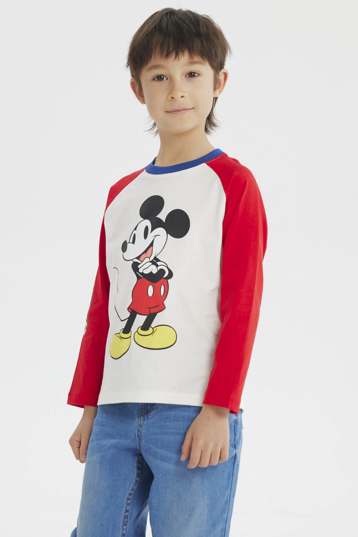 Polera beige de niño con estampado grande de Mickey Mouse en el frente estilo clásico con mangas largas rojas