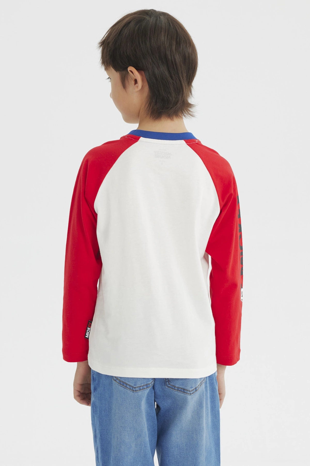 Polera beige de niño con estampado grande de Mickey Mouse en el frente estilo clásico con mangas largas rojas