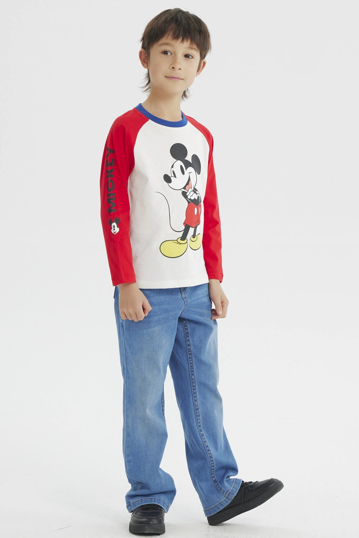 Polera beige de niño con estampado grande de Mickey Mouse en el frente estilo clásico con mangas largas rojas