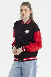 Polerón negro mujer con mangas rojas estampa Hello Kitty pequeña en el pecho estilo varsity y texto en el lateral