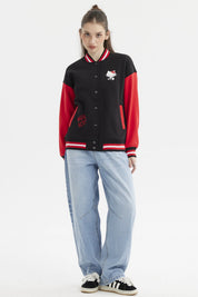 Polerón negro mujer con mangas rojas estampa Hello Kitty pequeña en el pecho estilo varsity y texto en el lateral