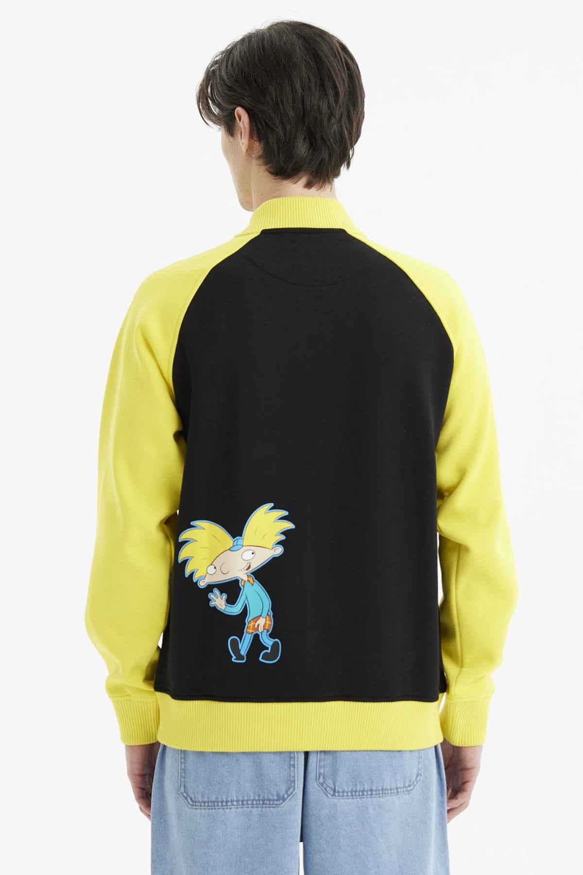 Polerón tipo college negro con mangas amarillas diseño Hey Arnold y letra A grande estilo universitario en el pecho