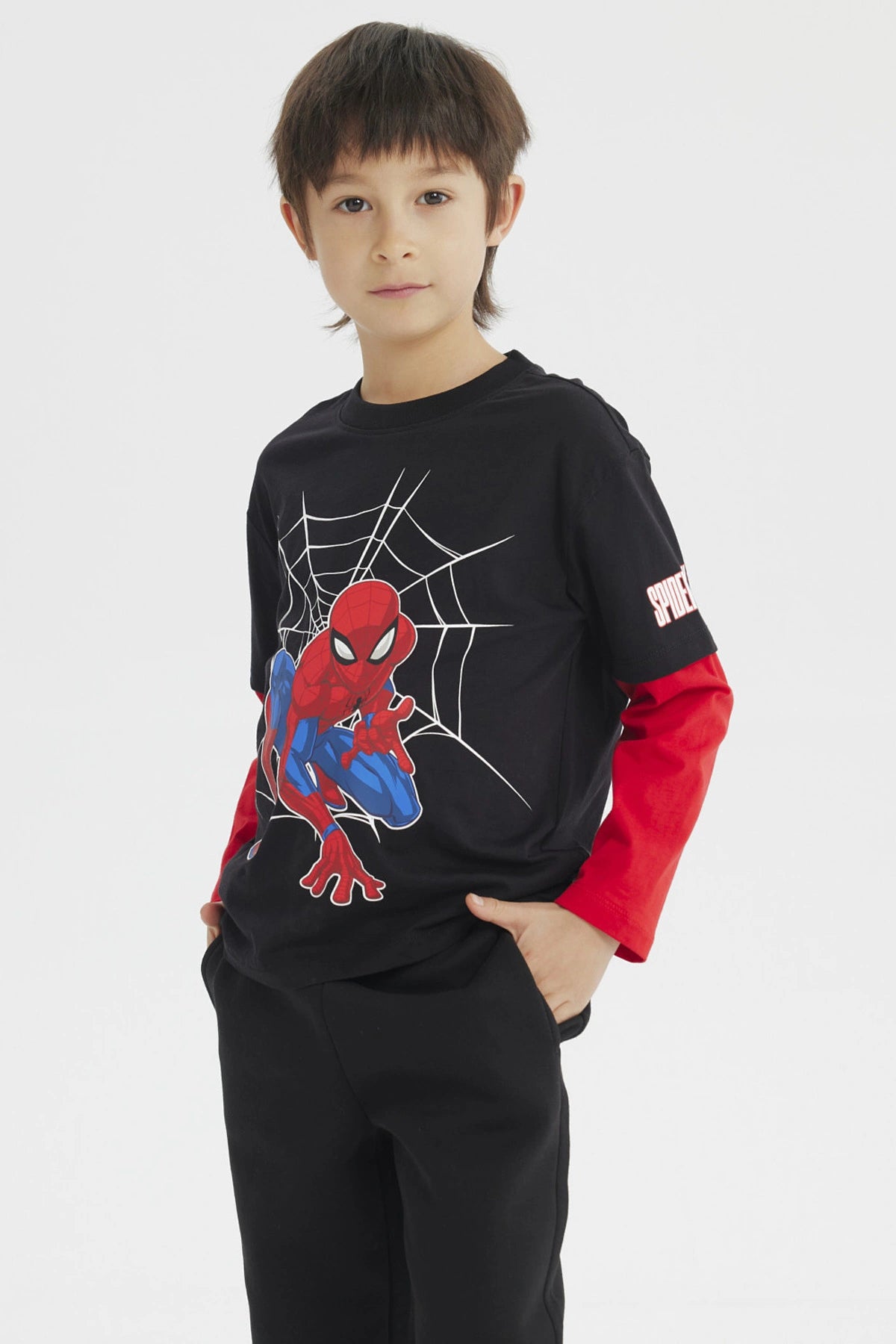 Polera niño negra con mangas rojas y estampado de Spiderman en acción sobre telaraña en el centro estilo cómic