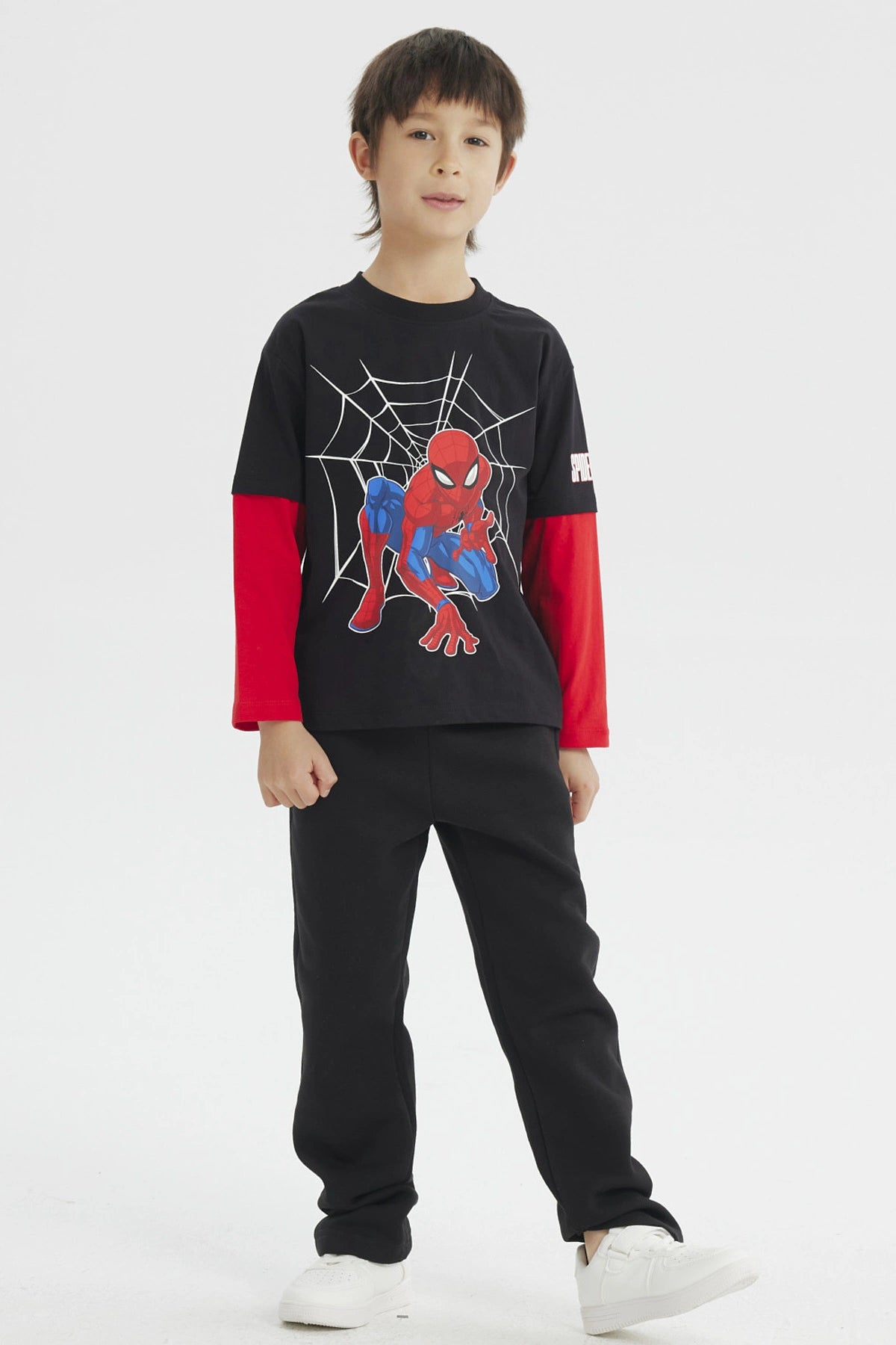 Polera niño negra con mangas rojas y estampado de Spiderman en acción sobre telaraña en el centro estilo cómic