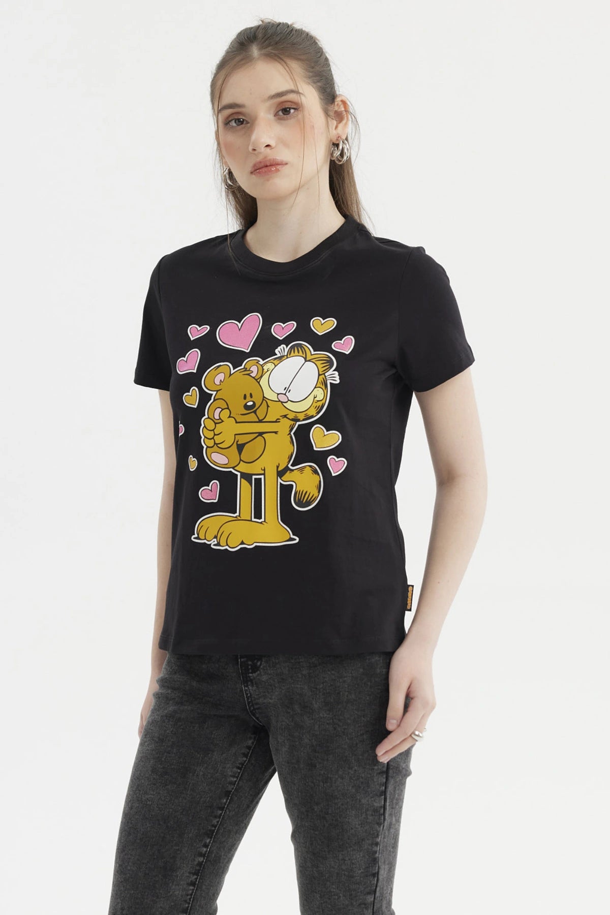 Polera negra de mujer con estampado grande al frente de Garfield abrazando un oso rodeado de corazones rosas y amarillos
