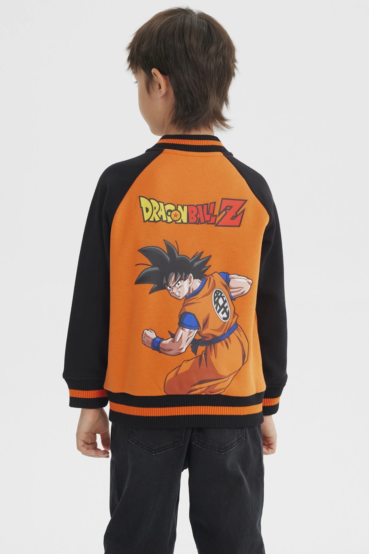 Polerón naranja para niño estilo college con mangas negras y logo pequeño en el pecho diseño inspirado en Dragon Ball