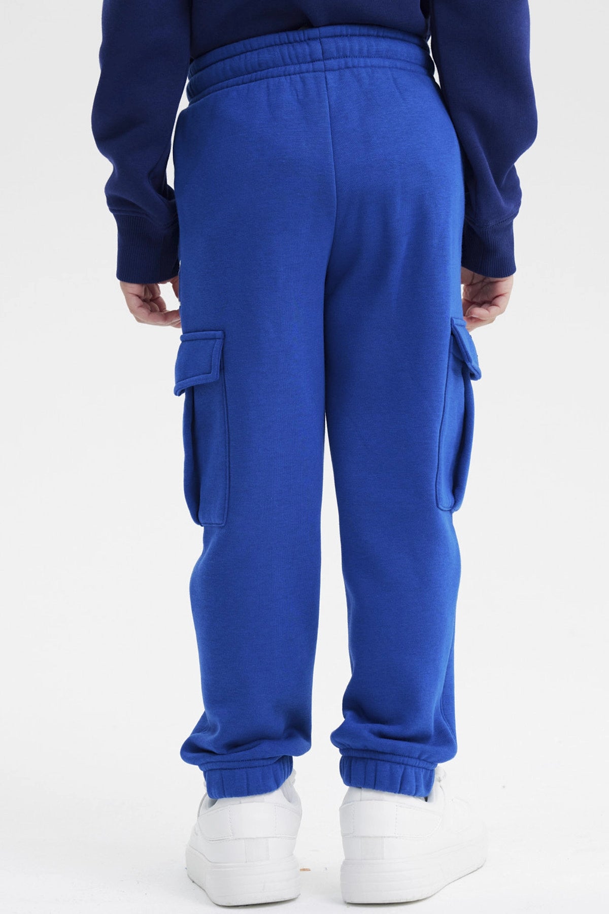 Pantalón jogger azul marino para niño con estampa de telaraña y máscara de superhéroe en el muslo izquierdo diseño gráfico animado