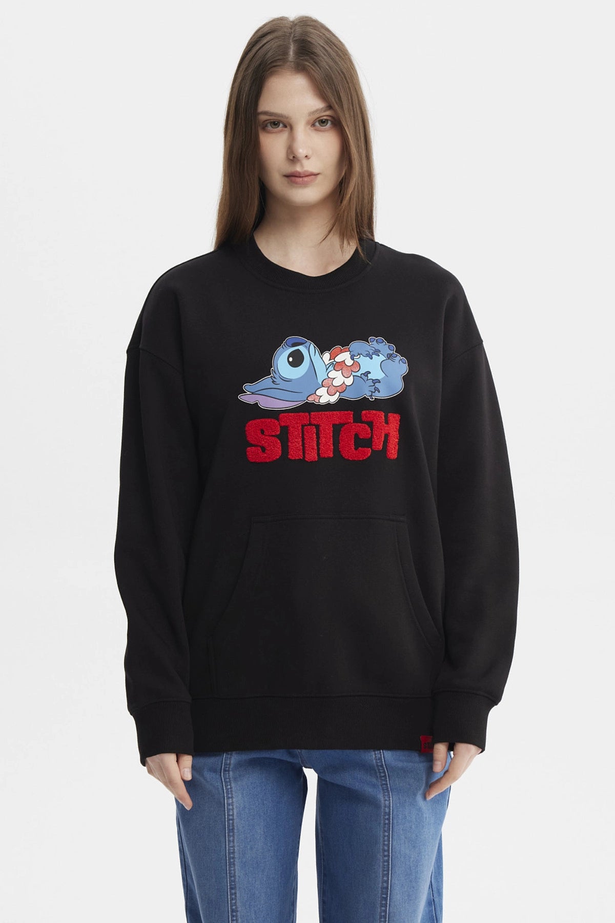 Polerón negro de mujer con estampado de Stitch recostado al frente estilo caricatura grande con texto rojo STITCH