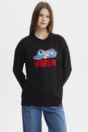 Polerón negro de mujer con estampado de Stitch recostado al frente estilo caricatura grande con texto rojo STITCH