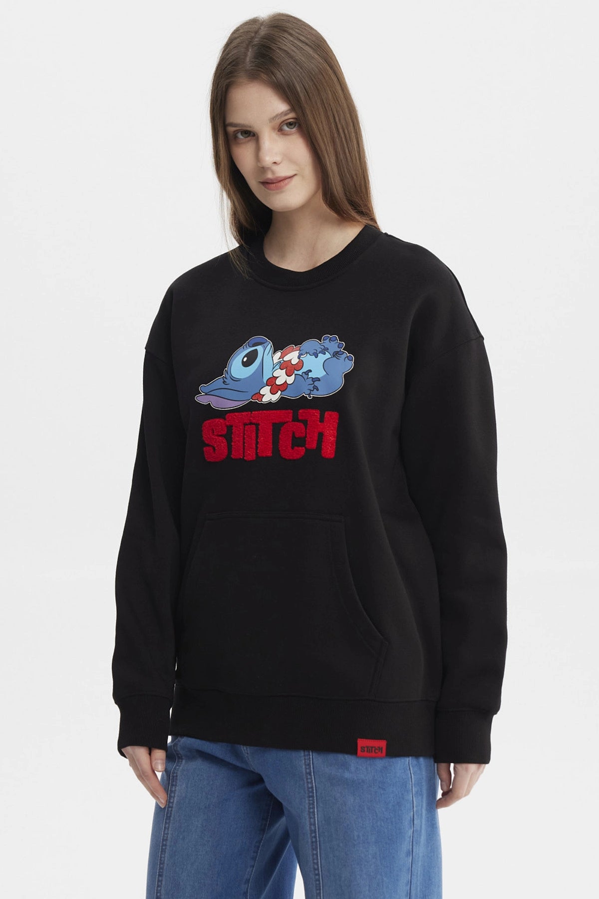Polerón negro de mujer con estampado de Stitch recostado al frente estilo caricatura grande con texto rojo STITCH
