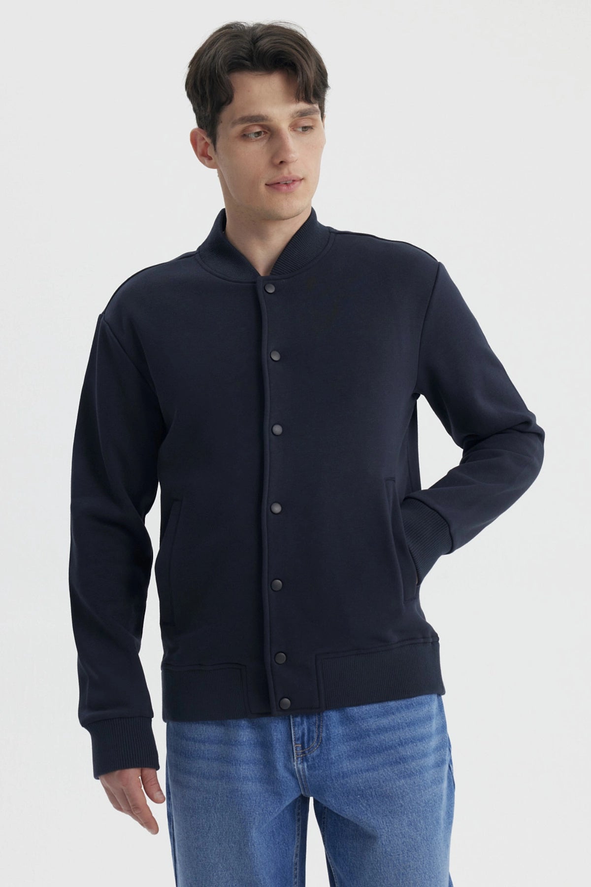 Chaqueta unisex azul marino con botones frontales y bolsillos laterales prenda lisa casual y versátil