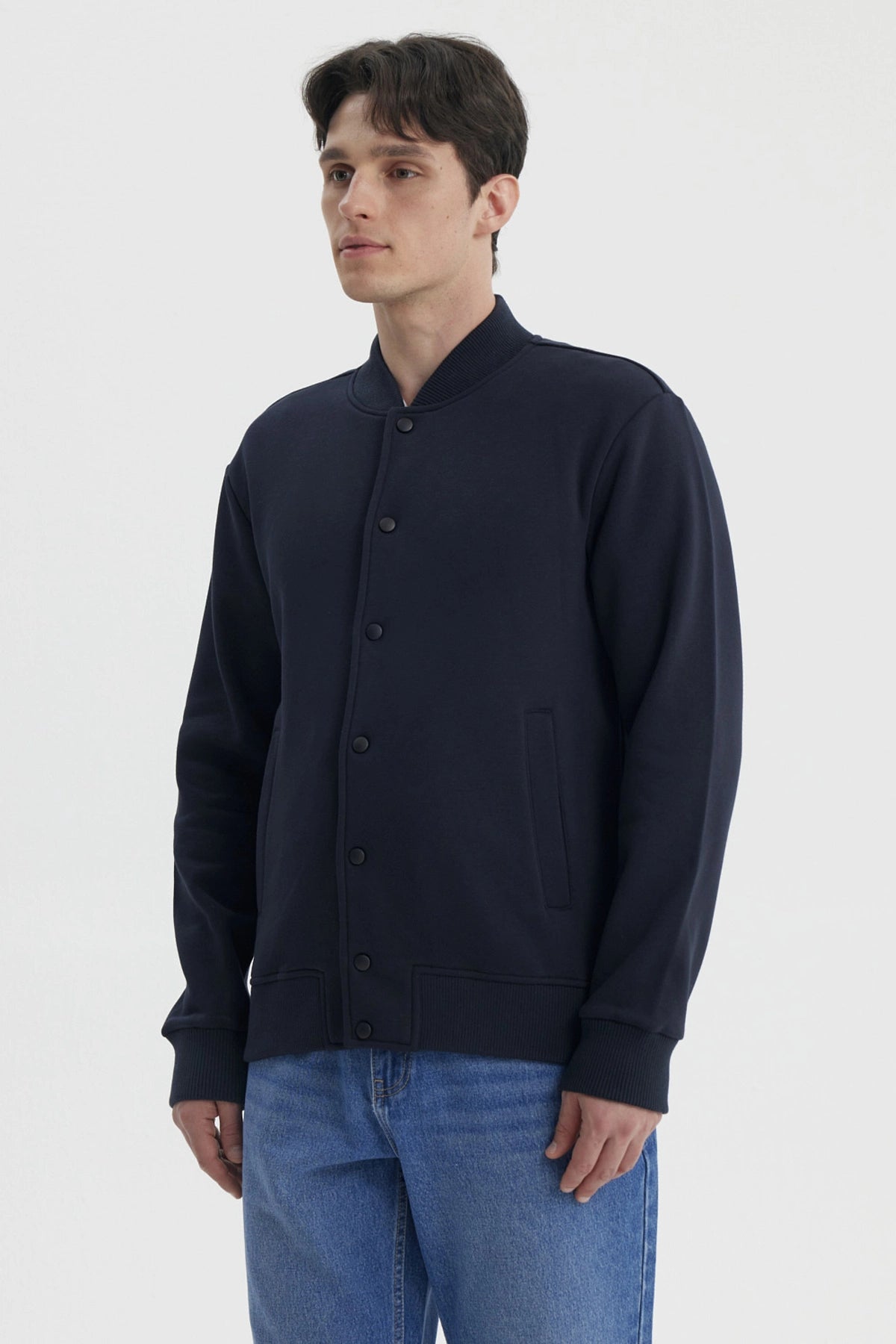 Chaqueta unisex azul marino con botones frontales y bolsillos laterales prenda lisa casual y versátil