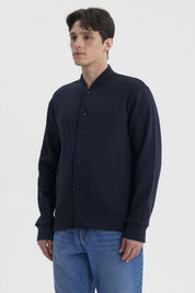 Chaqueta unisex azul marino con botones frontales y bolsillos laterales prenda lisa casual y versátil