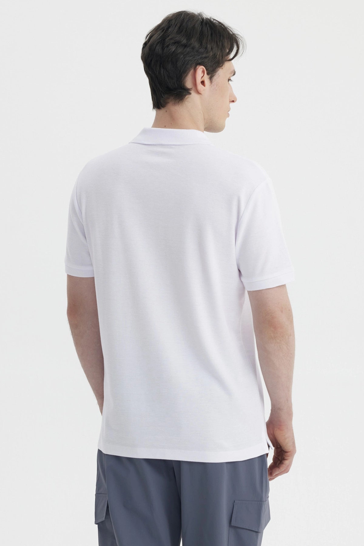 Polera blanca de hombre con cuello polo y mangas cortas prenda lisa ideal para un look casual y fresco