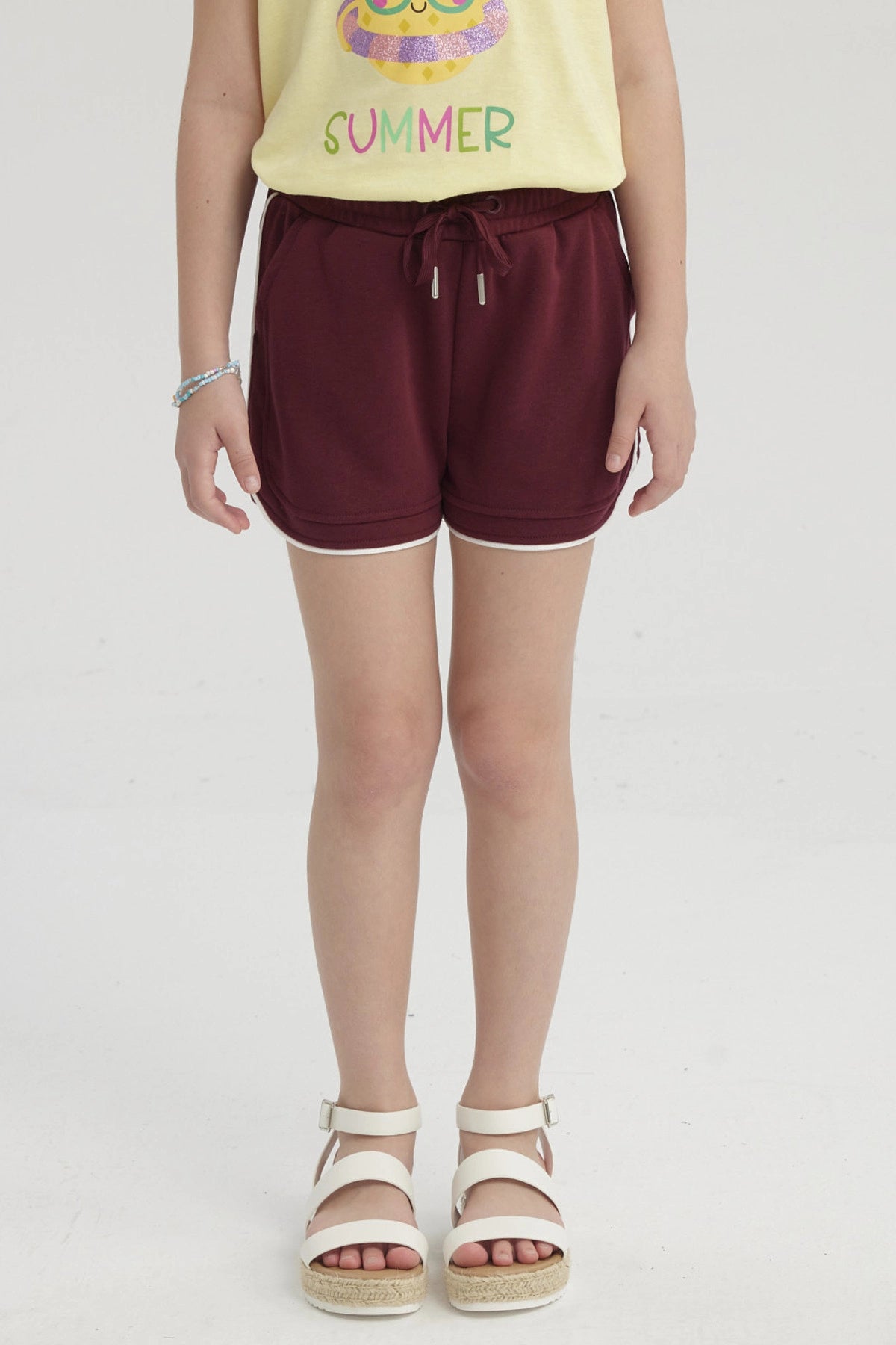 Short rojo niña con cordón elástico y borde blanco diseño liso cómodo para días soleados y juegos al aire libre