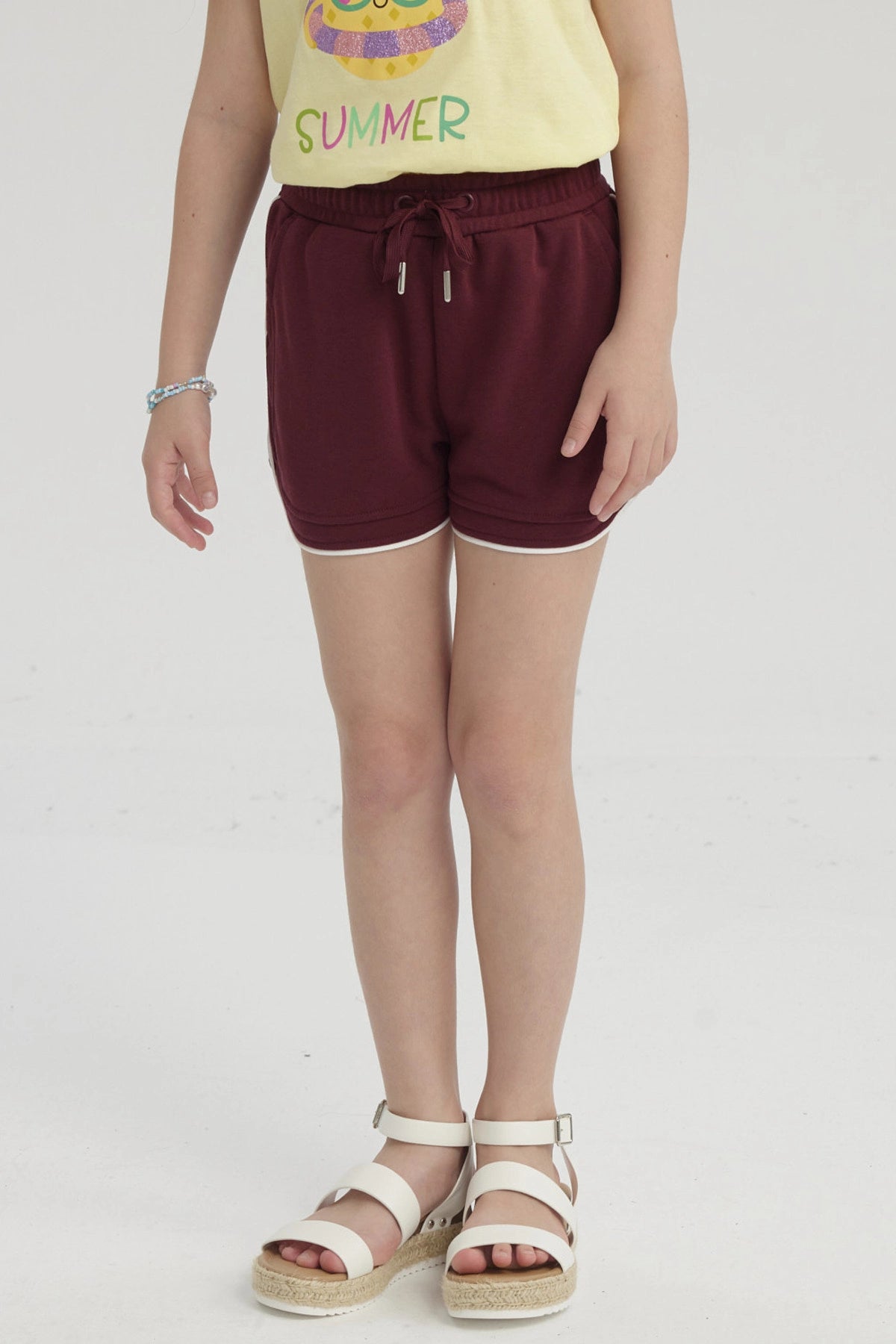 Short rojo niña con cordón elástico y borde blanco diseño liso cómodo para días soleados y juegos al aire libre