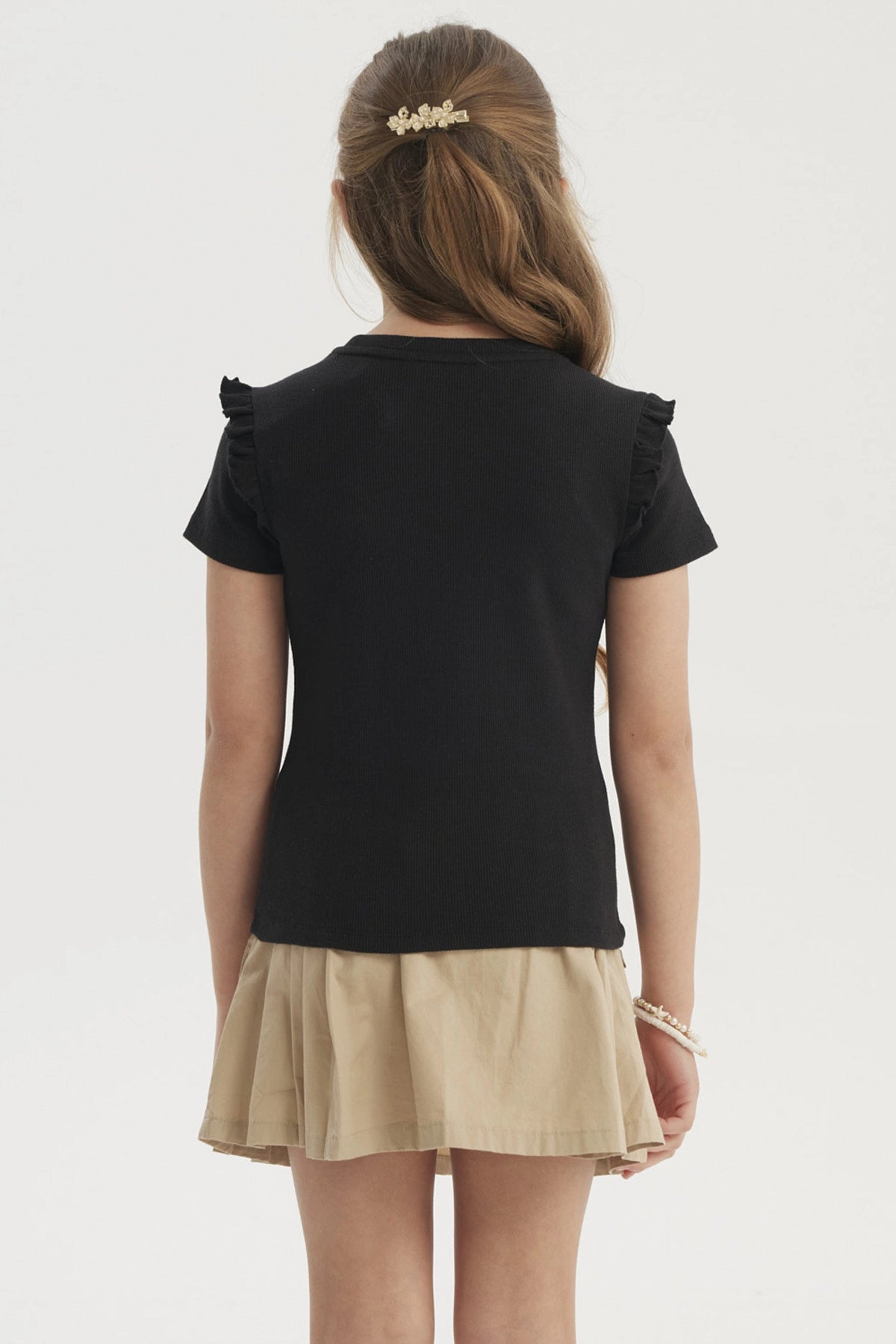 Polera negra para niña con vuelos en los hombros prenda lisa de algodón ideal para un look casual y cómodo