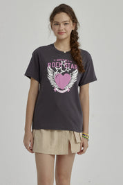 Polera niña gris oscuro con diseño de corazón rosa y alas blancas centrado en el pecho estilo gráfico