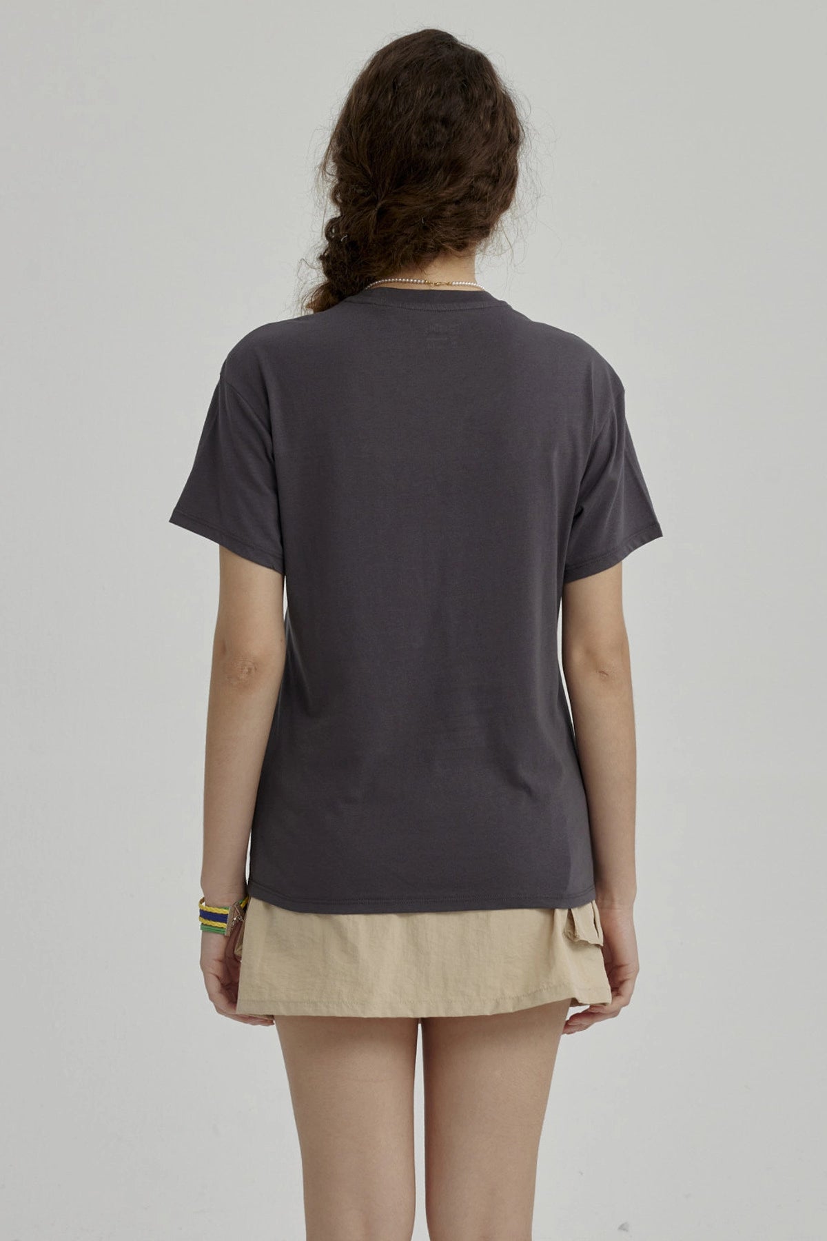 Polera niña gris oscuro con diseño de corazón rosa y alas blancas centrado en el pecho estilo gráfico