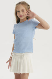 Polera celeste niña con textura visible en tejido ajustado manga corta diseño liso ideal para un look casual fresco