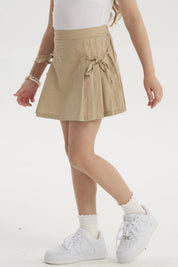 Falda beige de niña con pliegues laterales y lazos en la cintura diseño liso ideal para un look casual fresco