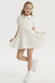 Vestido niña crudo con cuello redondo y mangas cortas detalle de lazo en cintura y diseño plisado liso