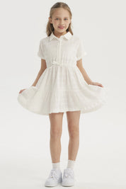 Vestido niña crudo con cuello redondo y mangas cortas detalle de lazo en cintura y diseño plisado liso