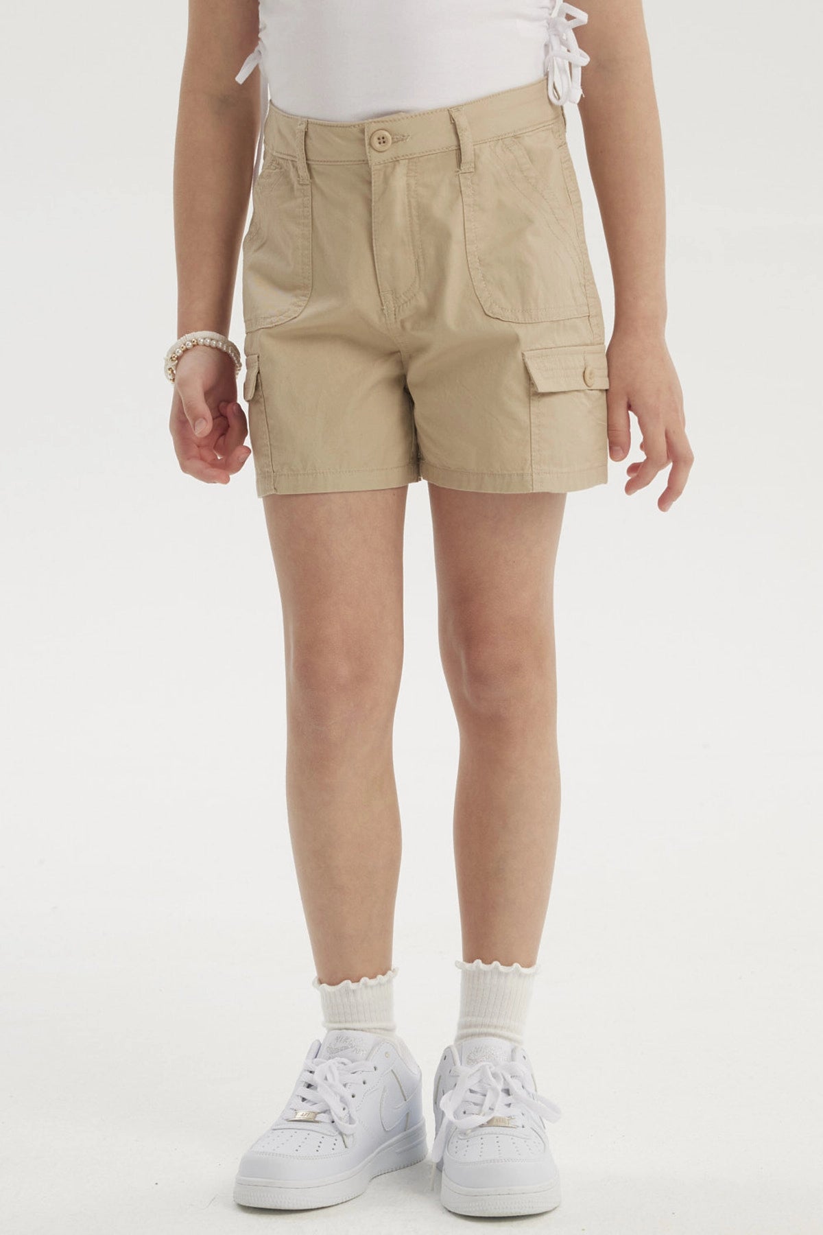 Short beige de gabardina para niña con bolsillos cargo amplios y botón frontal diseño liso