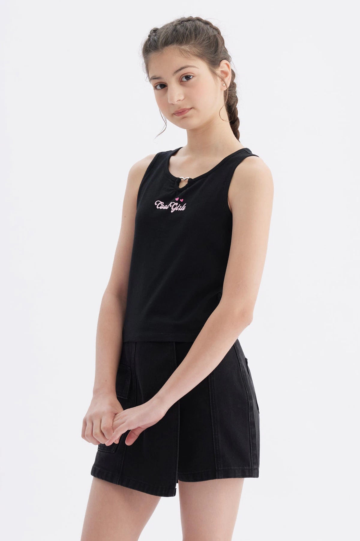 Polera negra para niña sin mangas con texto Cool Girl y corazones pequeños en el pecho estilo casual urbano