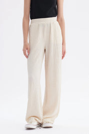 Pantalón niña wide leg beige textura lisa con cintura elástica y caída amplia hasta los tobillos