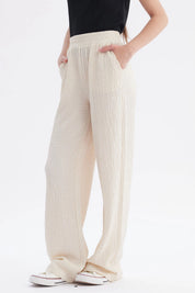 Pantalón niña wide leg beige textura lisa con cintura elástica y caída amplia hasta los tobillos