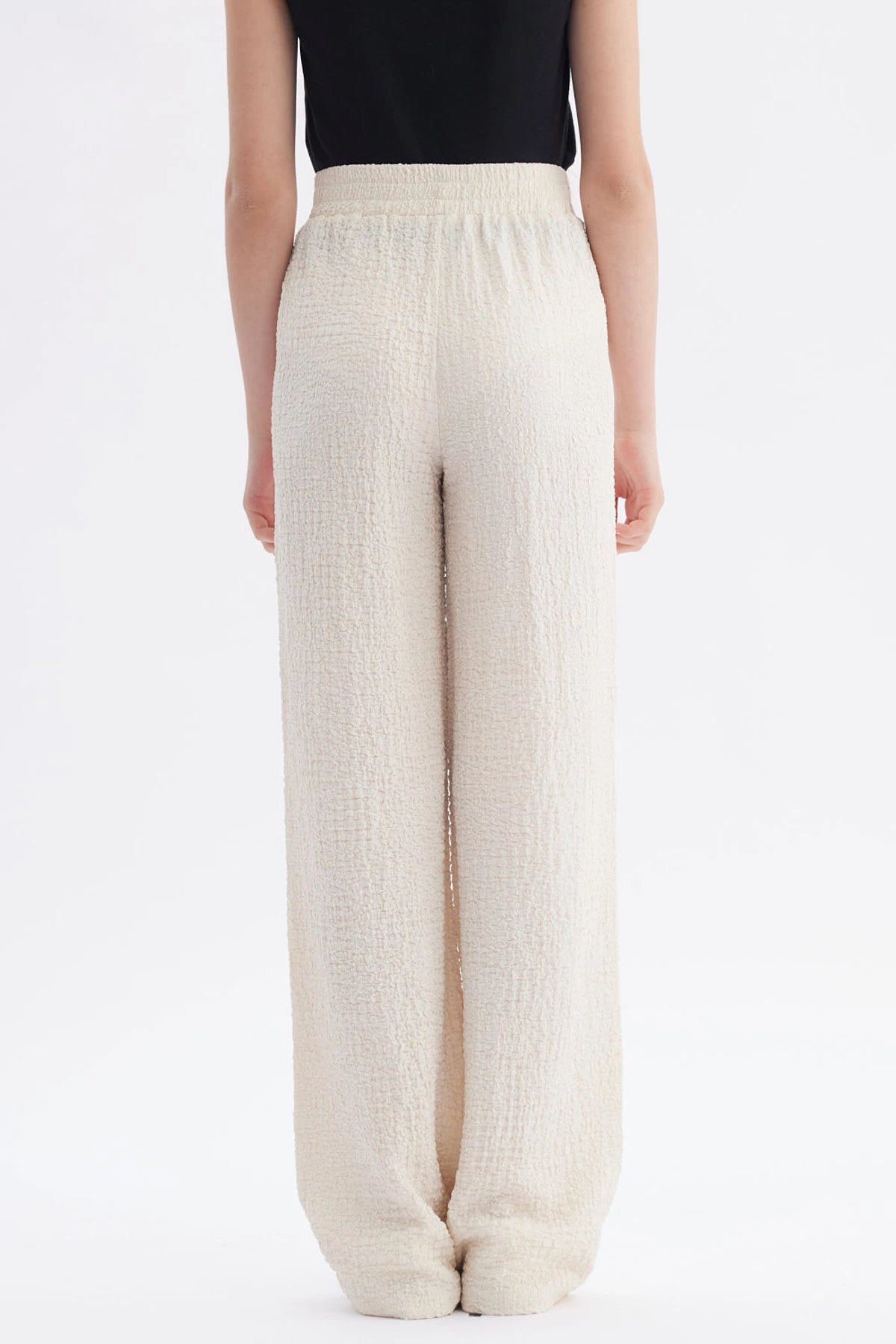 Pantalón niña wide leg beige textura lisa con cintura elástica y caída amplia hasta los tobillos