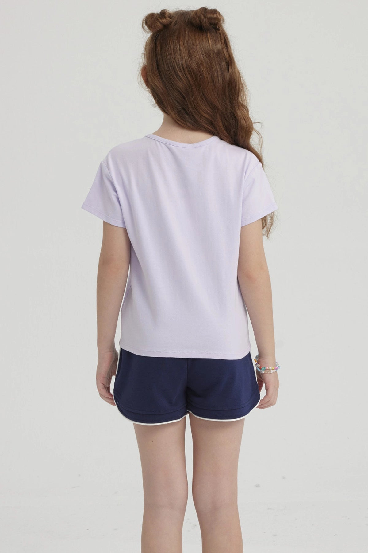 Polera morada para niña con nudo en el frente y estampa de conchas y olas en el pecho estilo dibujo infantil