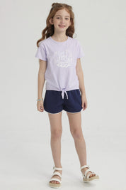 Polera morada para niña con nudo en el frente y estampa de conchas y olas en el pecho estilo dibujo infantil