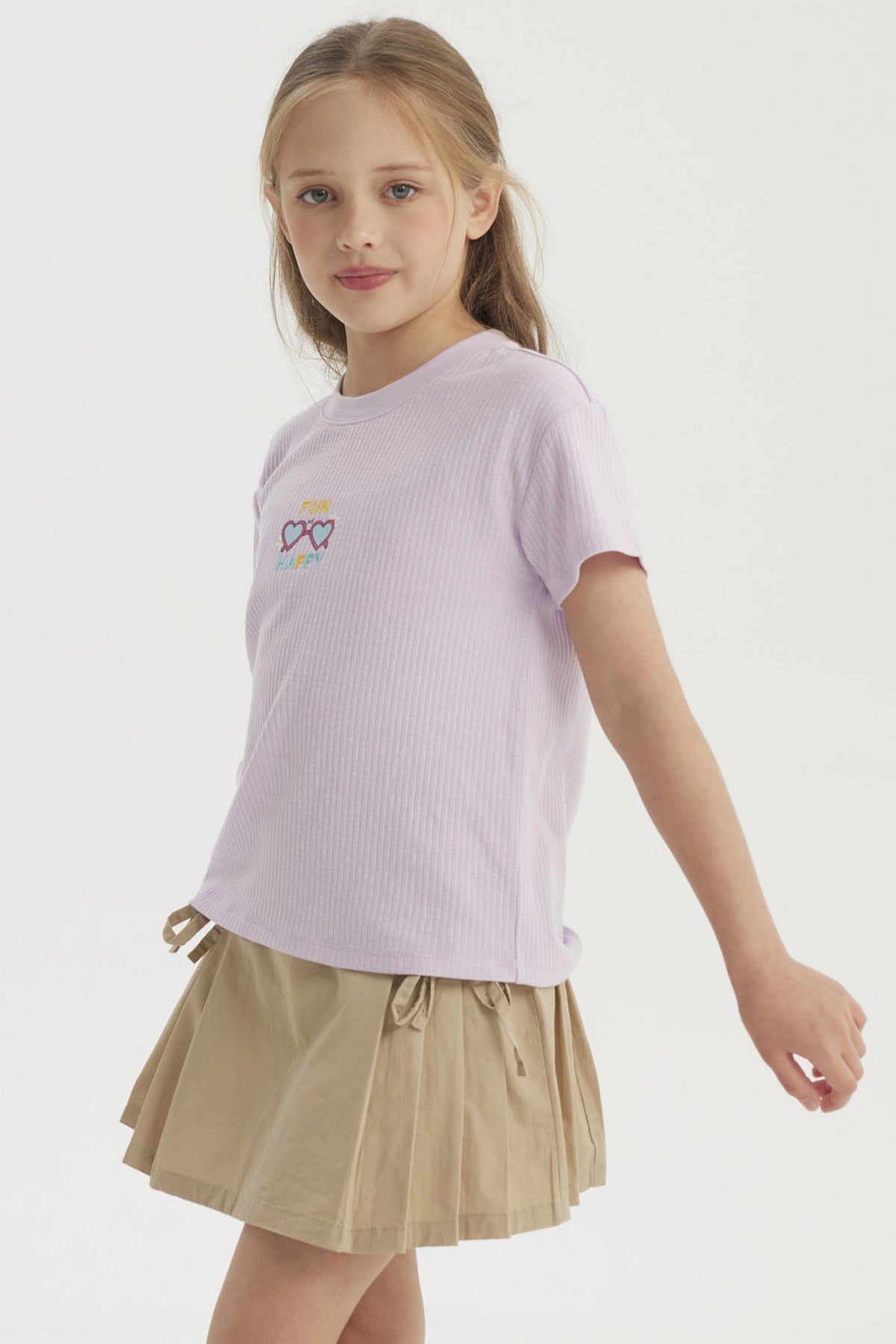 Polera lila de niña con diseño pequeño de gafas corazón y texto Fun Happy en el centro estilo gráfico colorido