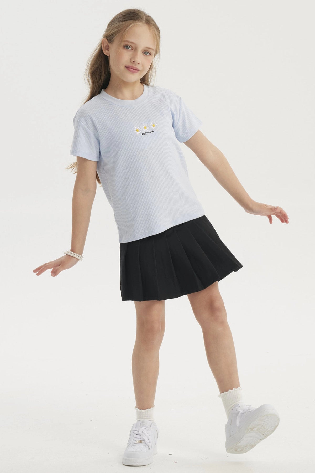 Polera celeste para niña con diseño de margaritas y texto Keep Smile en el pecho estilo casual y alegre