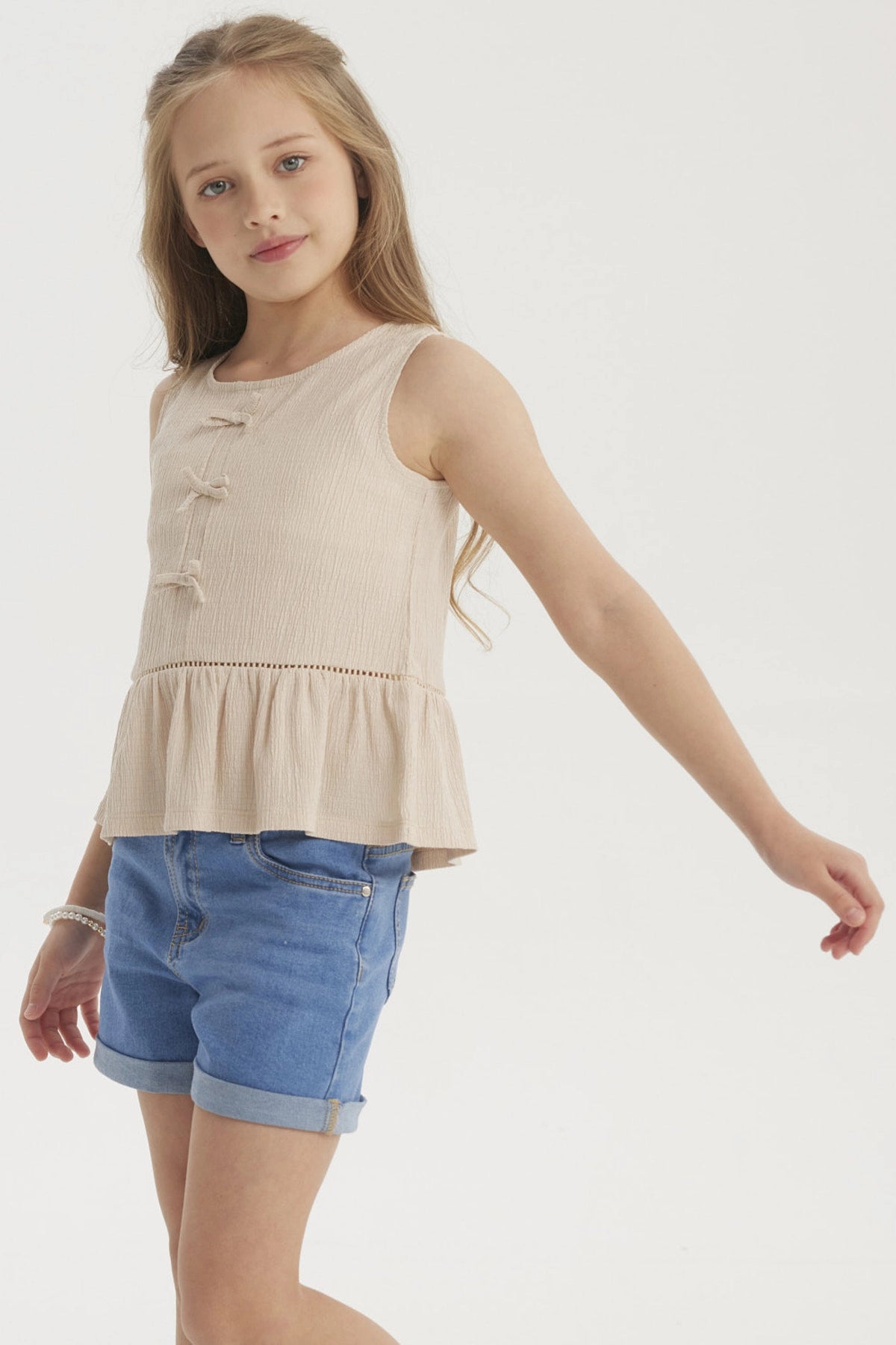 Polera beige para niña con cintas decorativas en el frente diseño liso sin mangas ajuste cómodo