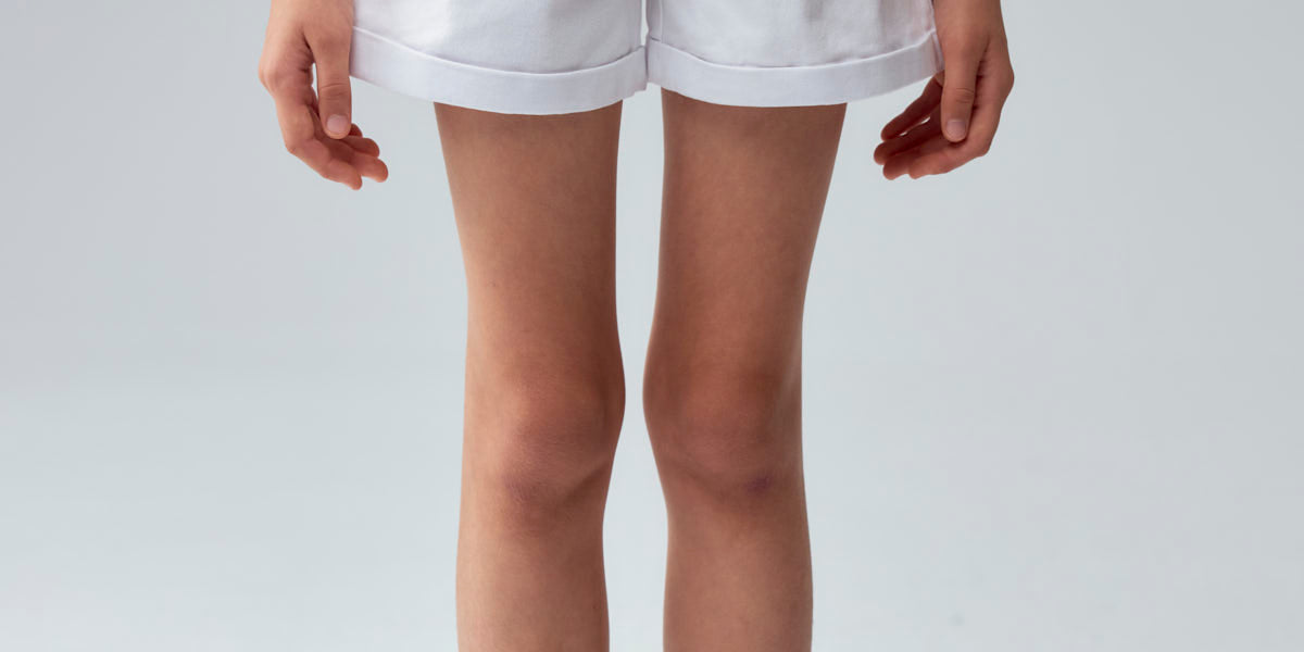 Short blanco para niña con diseño básico y botón visible