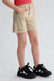 Short de niña beige con bolsillos y botón frontal visible