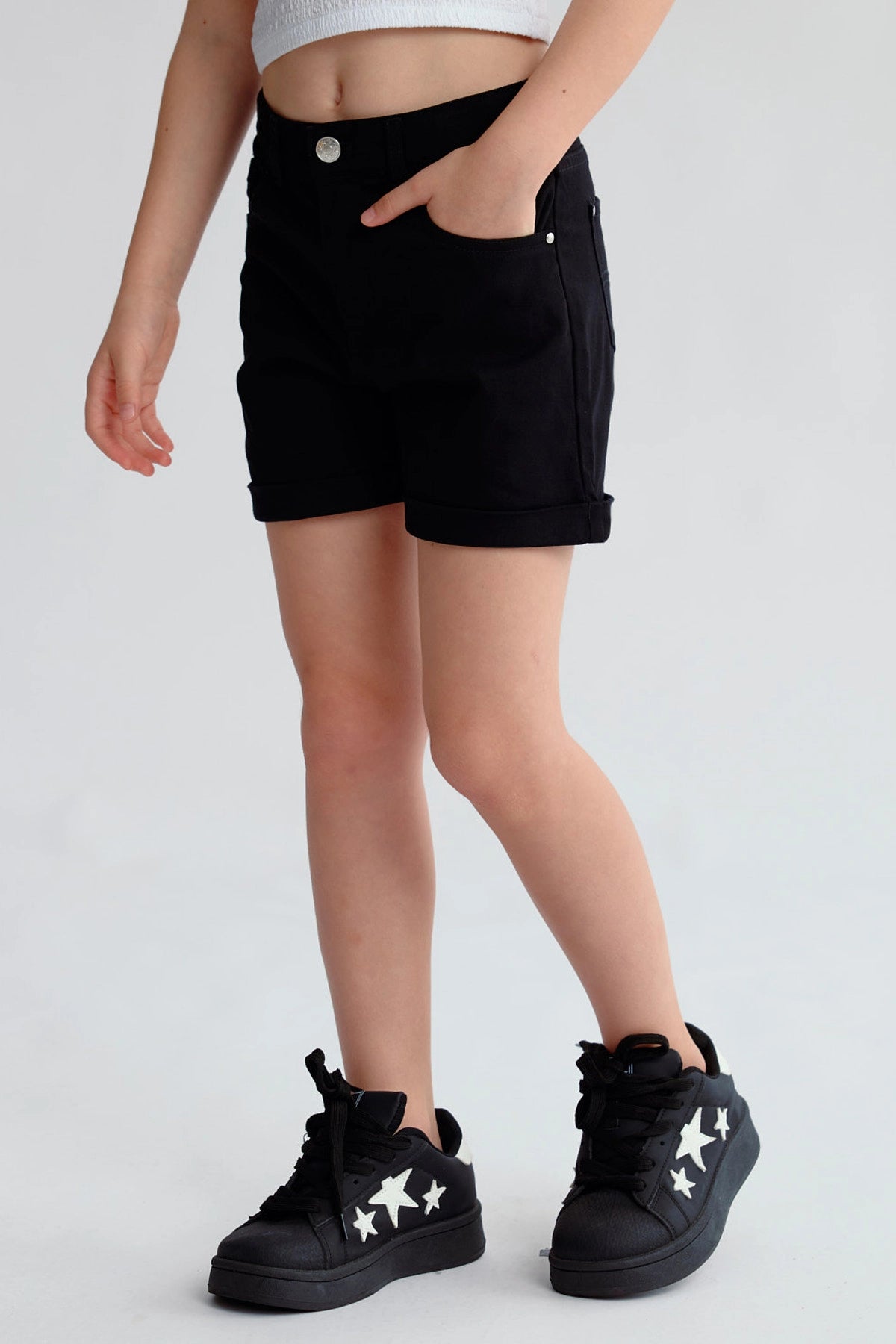 Short negro de gabardina para niña con dobladillo y botón plateado visible