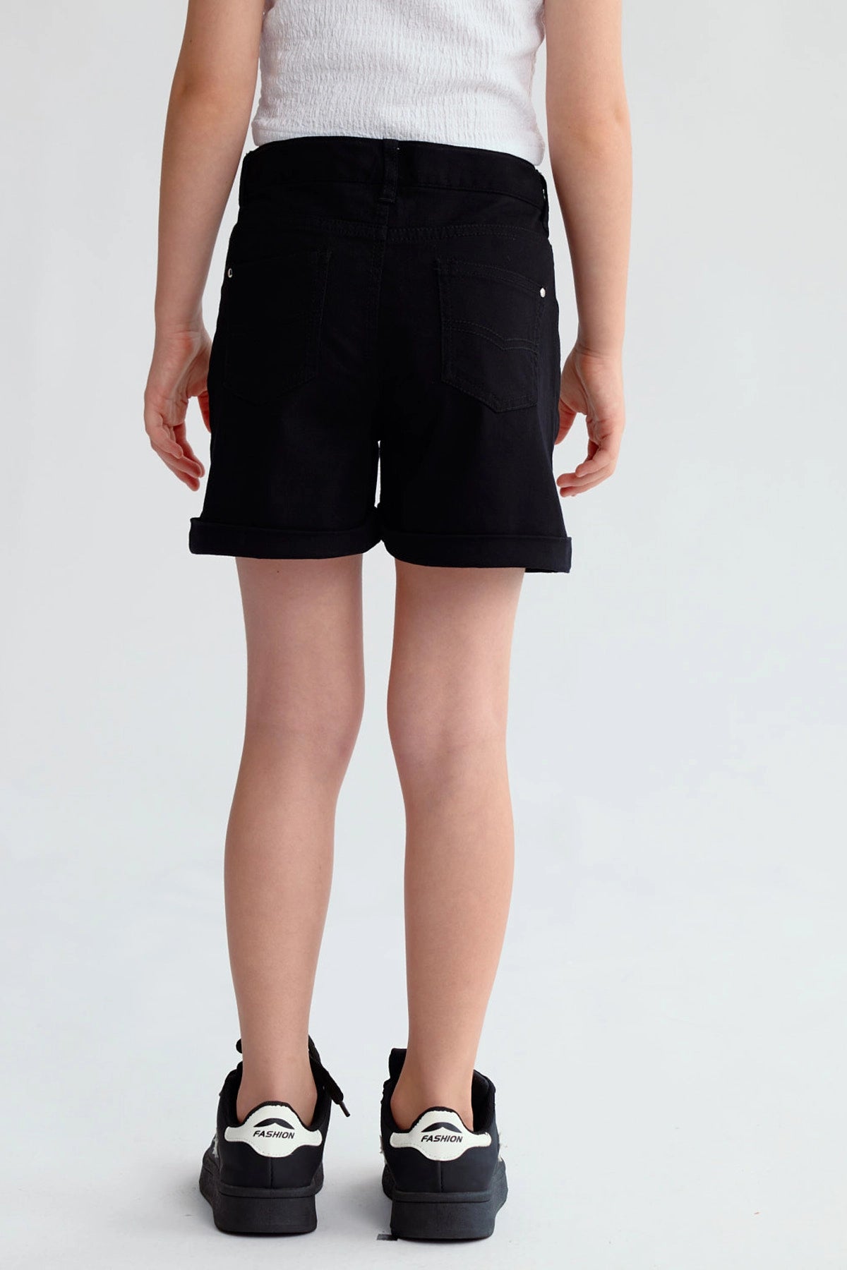 Short negro de gabardina para niña con dobladillo y botón plateado visible