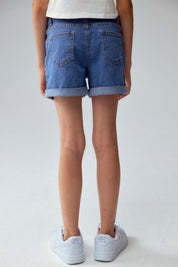 Short de niña azul denim con dobladillo doblado y bolsillos frontales visibles