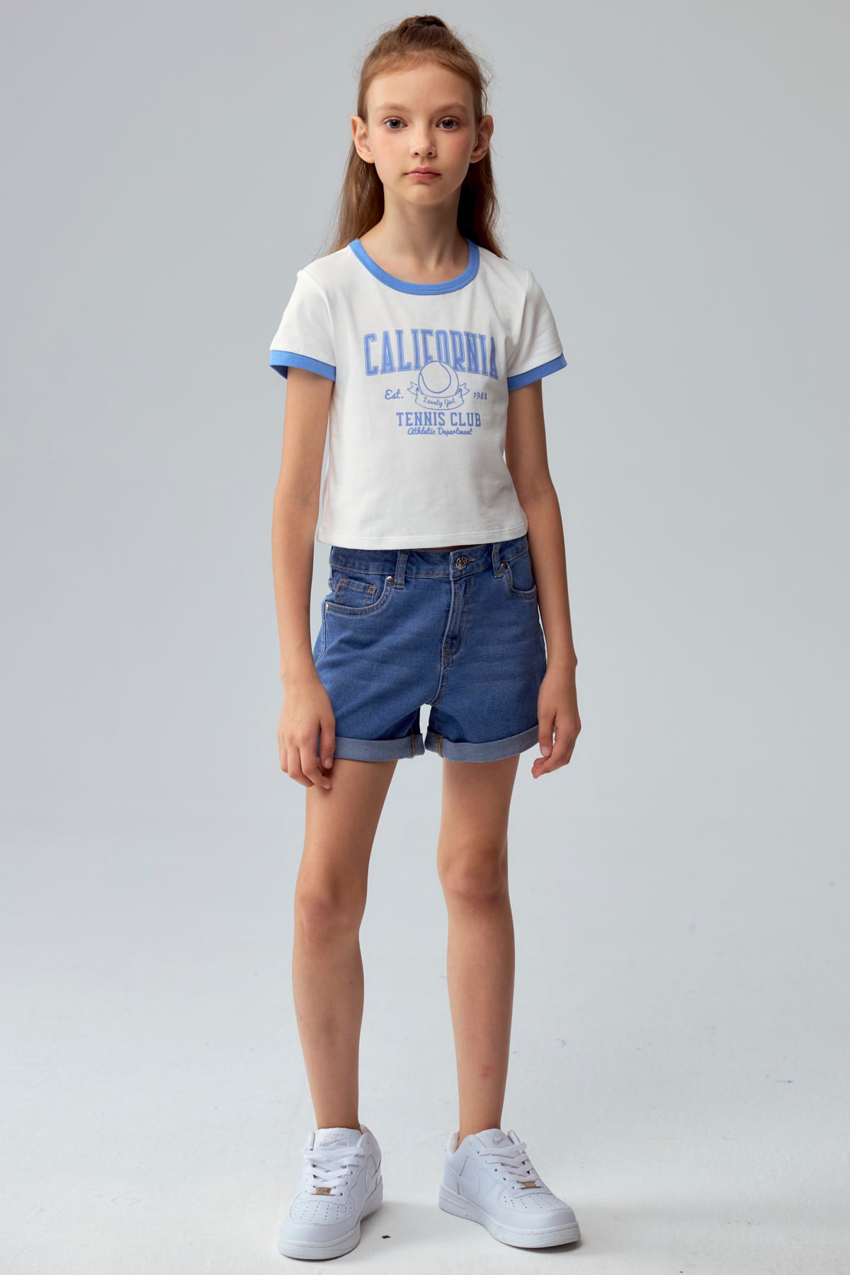 Short de niña azul denim con dobladillo doblado y bolsillos frontales visibles