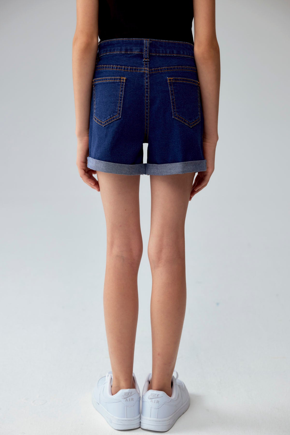 Short básico de niña en denim azul oscuro con dobladillo visible