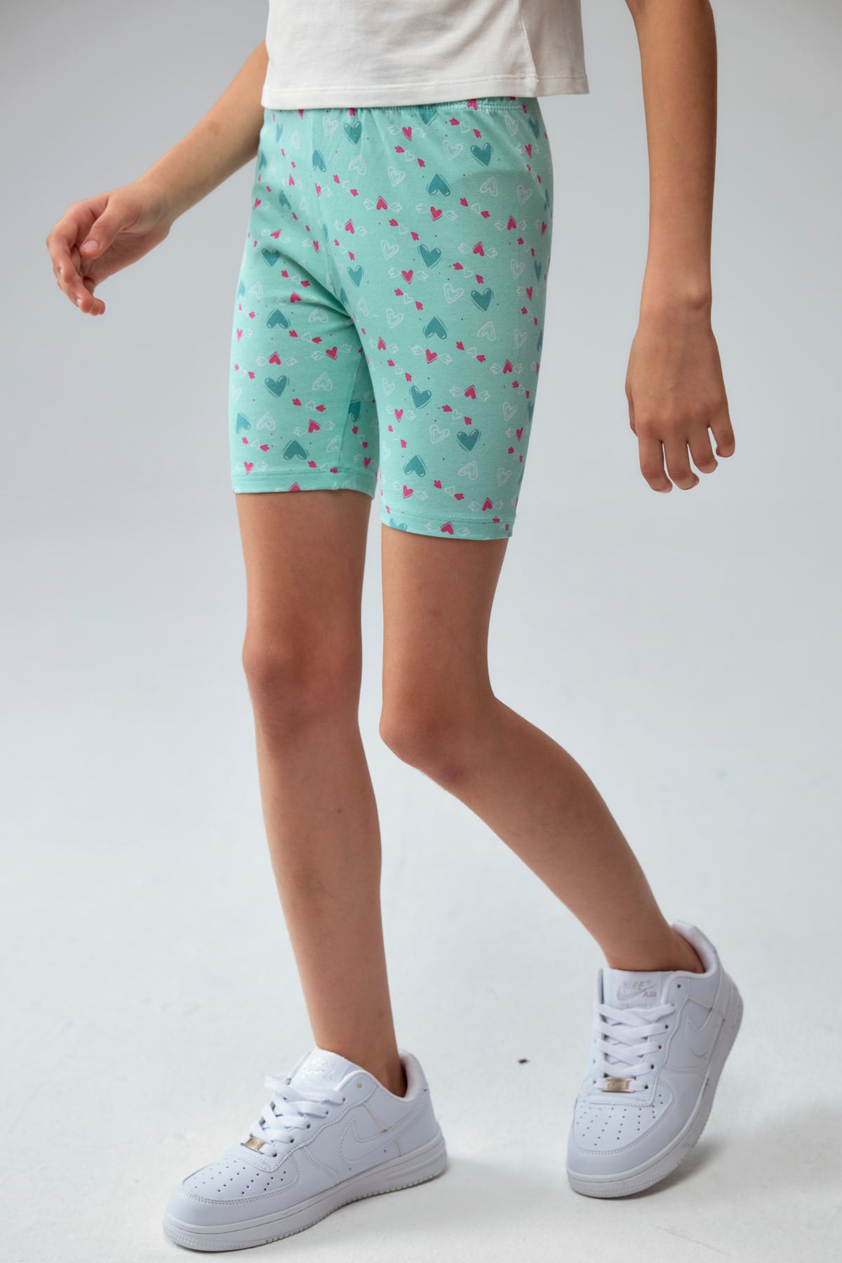 Calza niña biker turquesa con estampado de corazones pequeños en varios colores