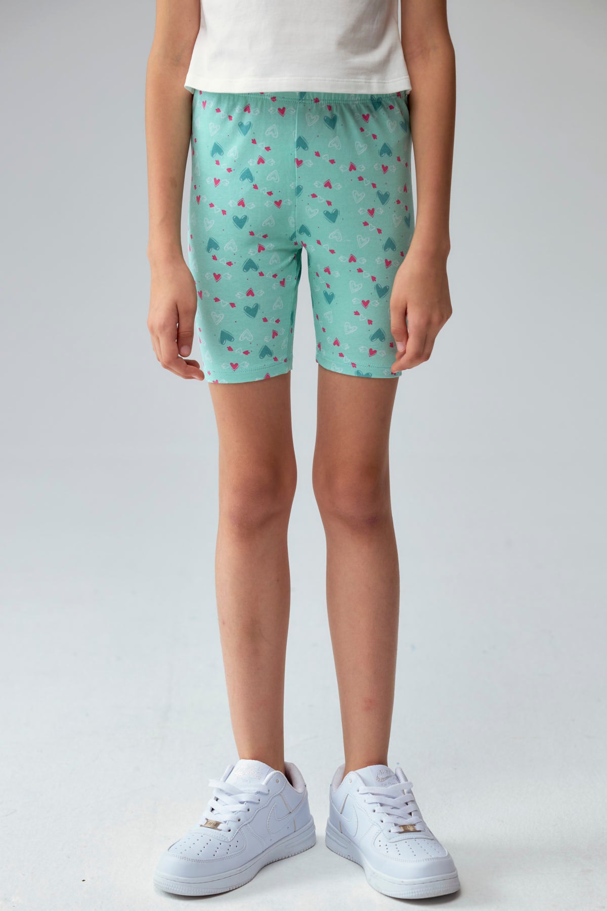 Calza niña biker turquesa con estampado de corazones pequeños en varios colores