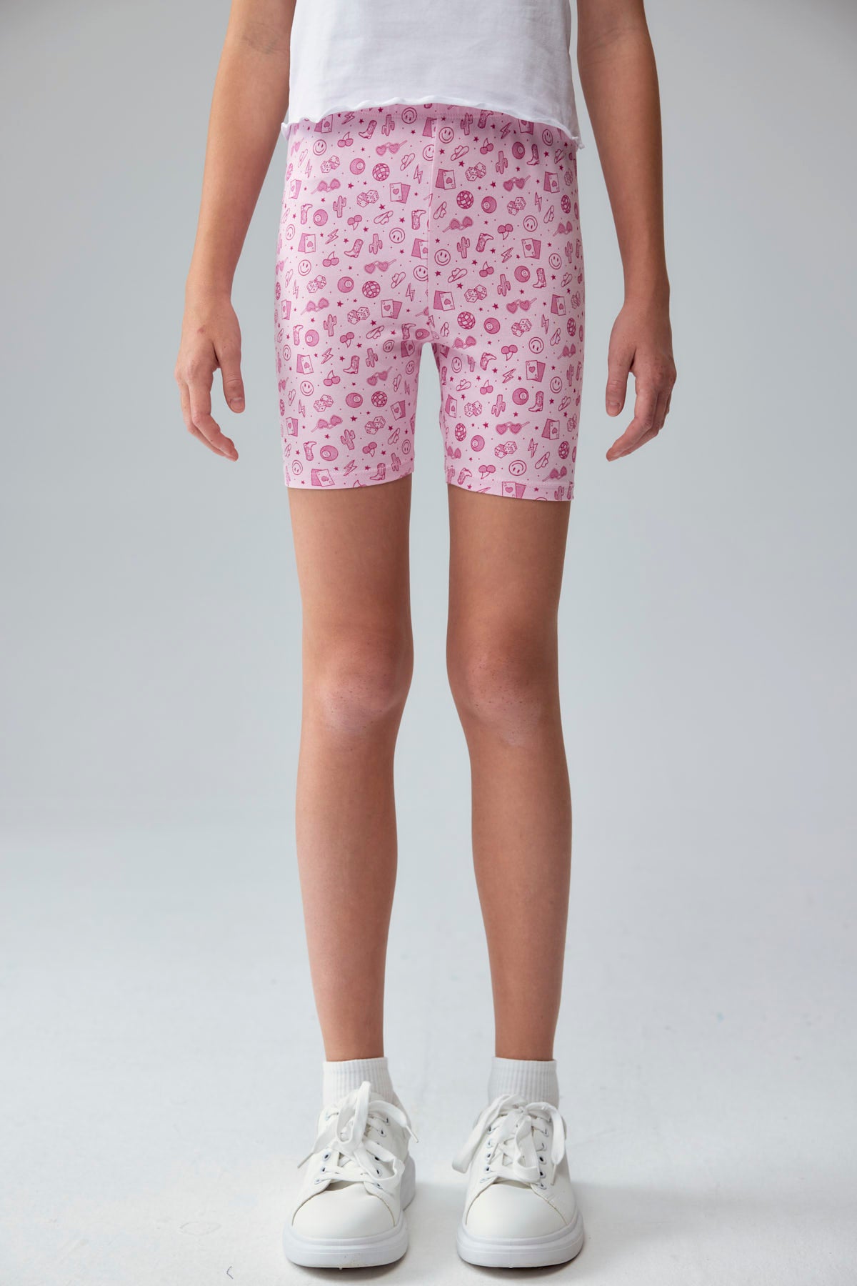Calza niña biker rosado con estampado de íconos en fondo claro